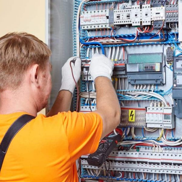 Electrician working on electrical switches — John McEwan Electrical in Wollongong, NSW